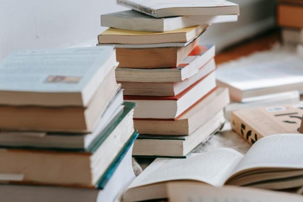 A collection of stacked books on the floor, perfect for cozy reading and literature themes.